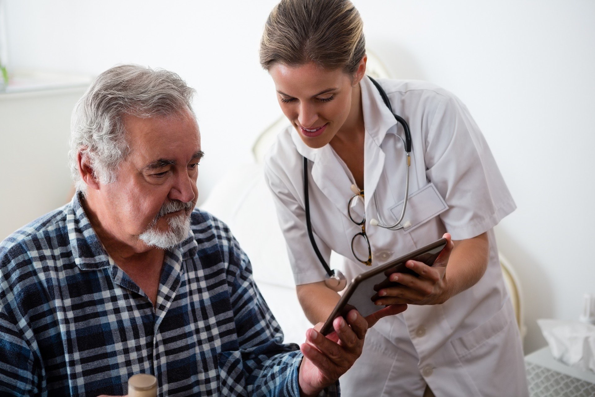 Ärztin bespricht Befunde mit einem älteren Patienten