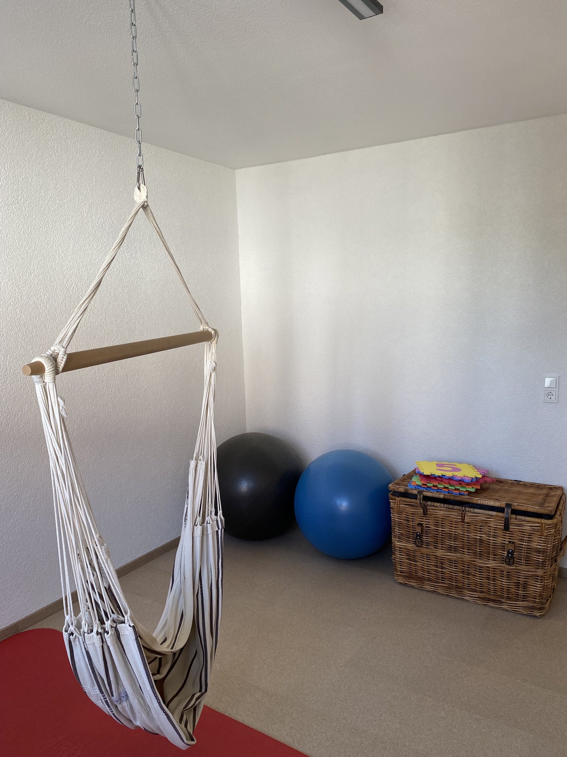 Therapieraum mit Hängesessel, Trampolin und Bodenmatten
