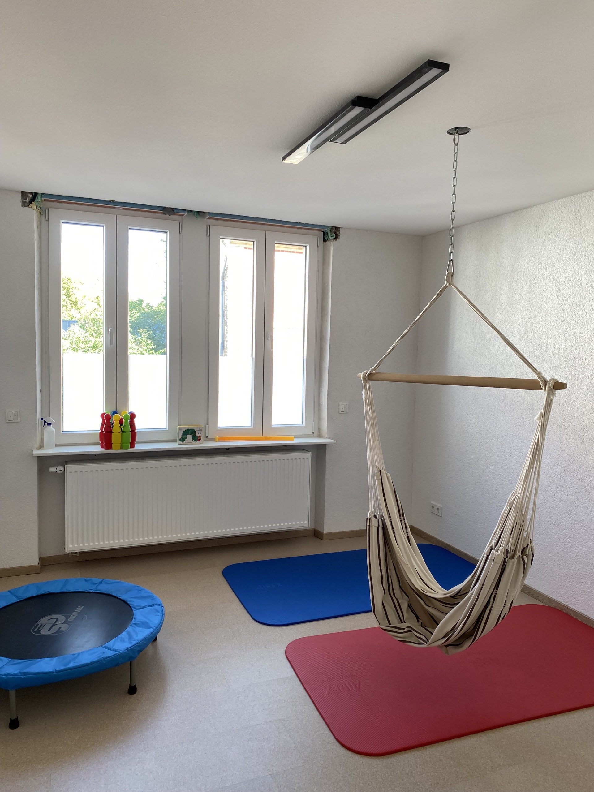 Behandlungsraum mit Arbeitstisch und Materialschrank